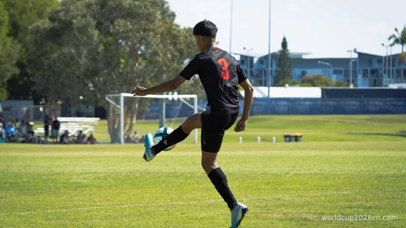 a man kicking a soccer ball across a field