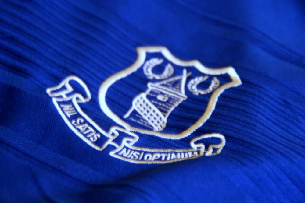 Medium shot of a football player wearing a generic blue training jersey, blurred