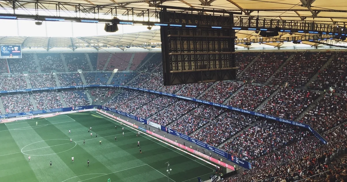 Wide shot of a packed massive football stadium during a World Cup match, vibrant crowd of