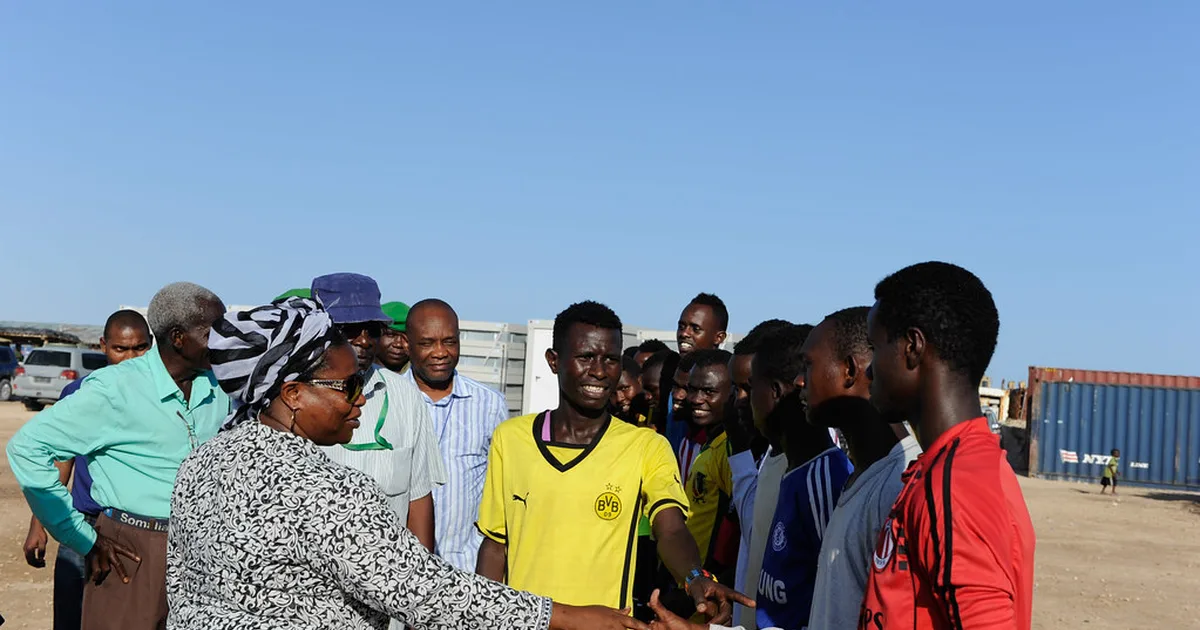 Wide shot of a youth football match final, golden hour light, players in generic unbranded