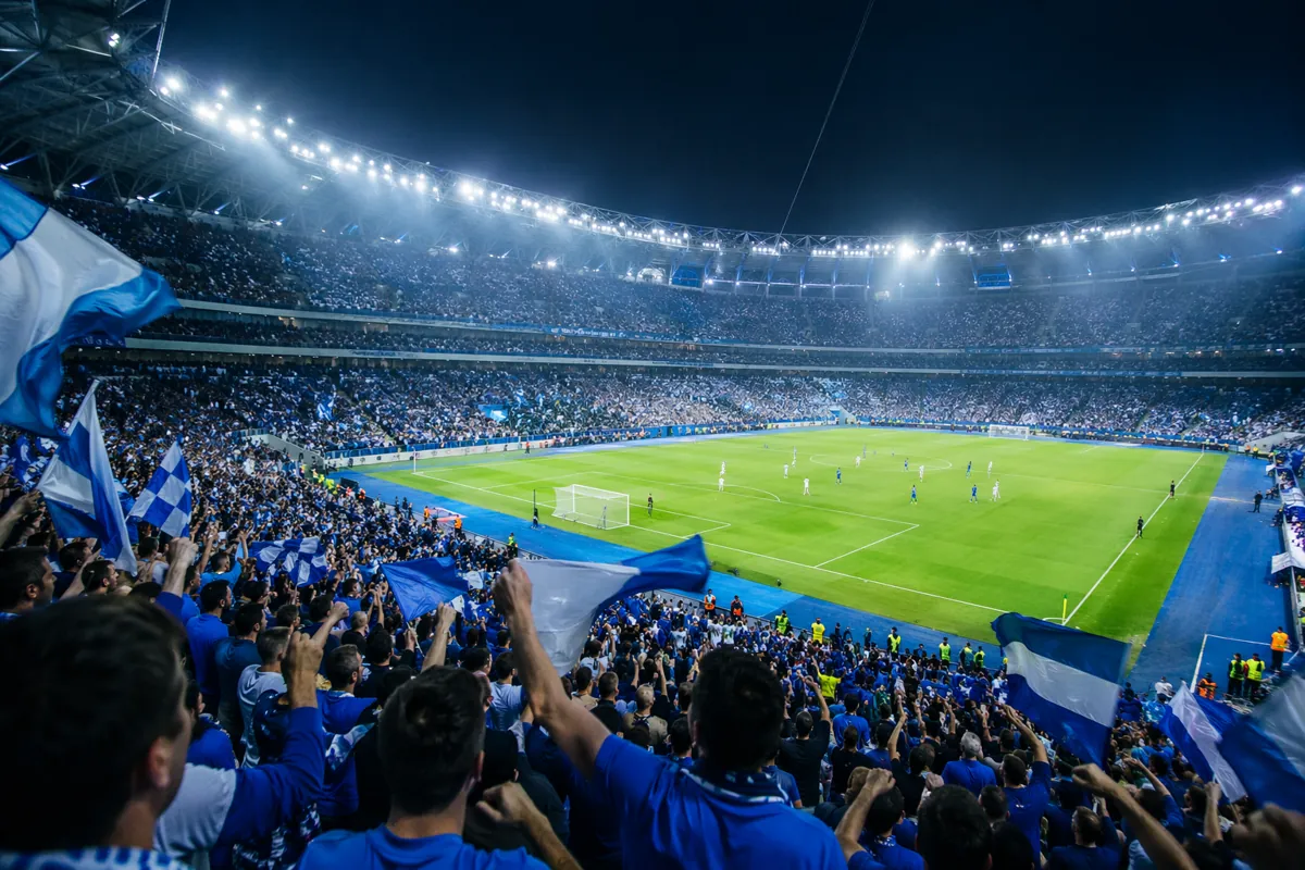 Wide shot of a professional football stadium during an international match, vibrant blue a