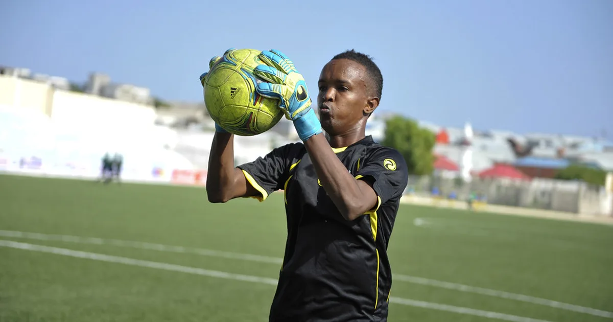 Professional football stadium during a top league match, blurred view of goalkeeper in uni