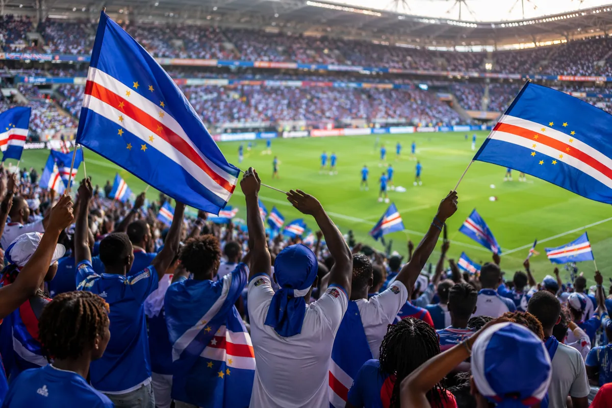 Wide shot of vibrant Cape Verde football fans waving blue and white flags in a sunlit Worl