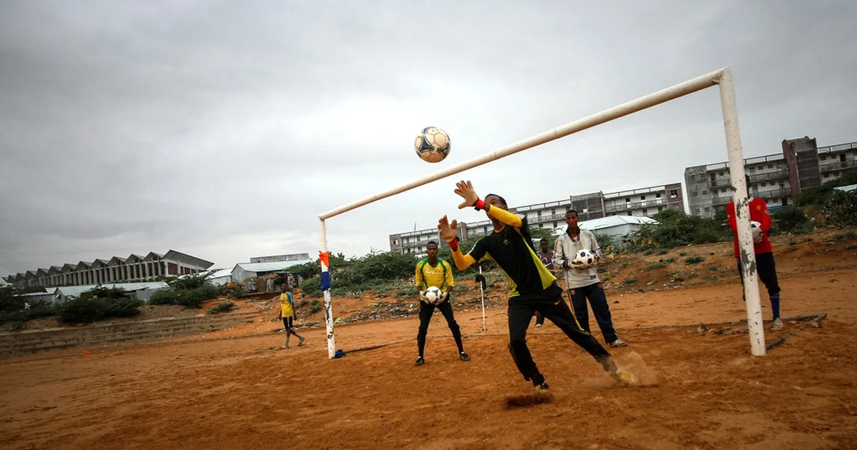 Wide shot of a professional football match, players in blue kits running on the green pitc
