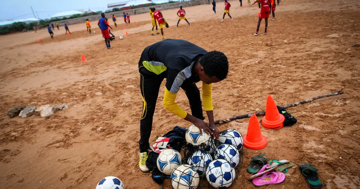 A wide shot of a World Cup football match in extra time, a forward is shooting the ball to