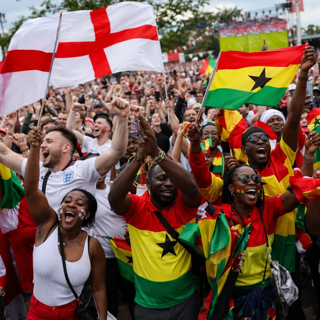 Wide shot of diverse football fans celebrating in a public viewing area, holding