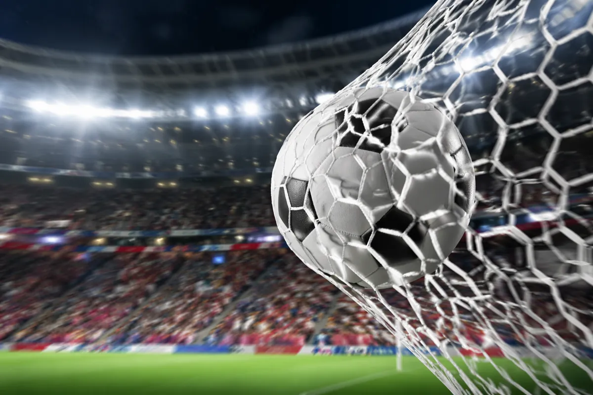 Close-up shot of a football flying into the back of the net at a professional World Cup st