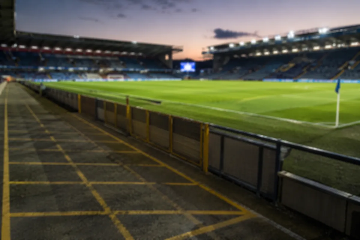Blurred view of a football stadium sideline with an empty designated standing penalty area