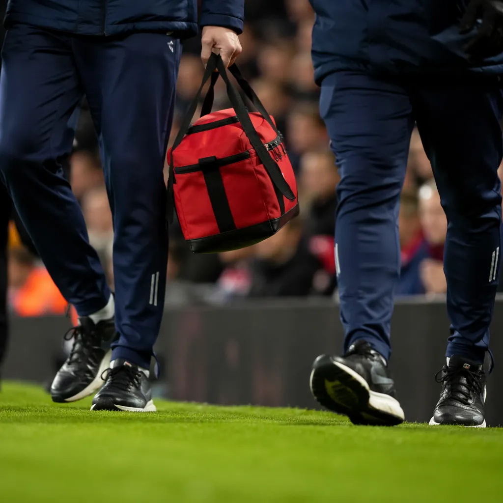 Close up of a medical team carrying a first aid kit walking along the edge of a