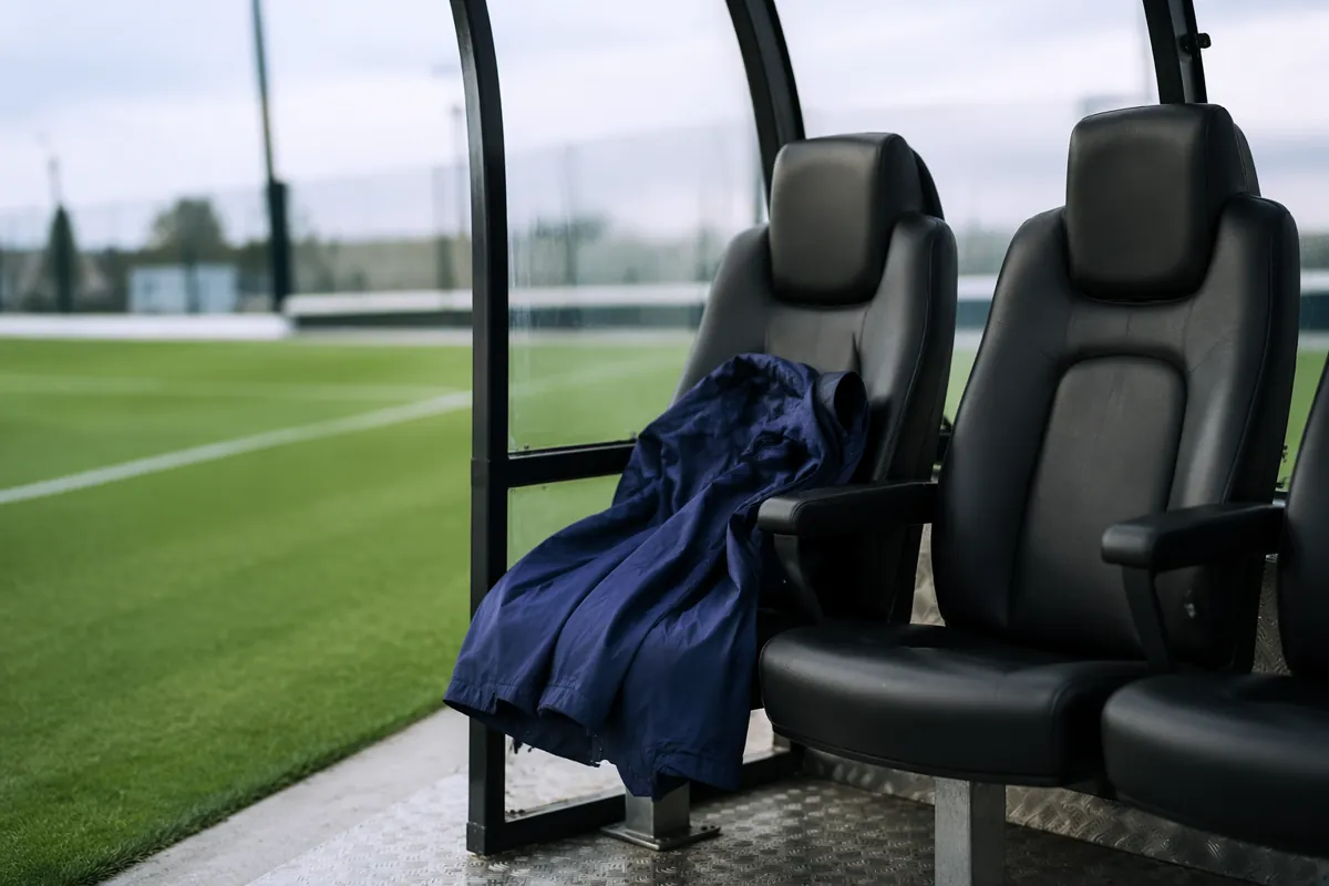 Empty head coach seat on a professional football team's sideline bench at a modern trainin