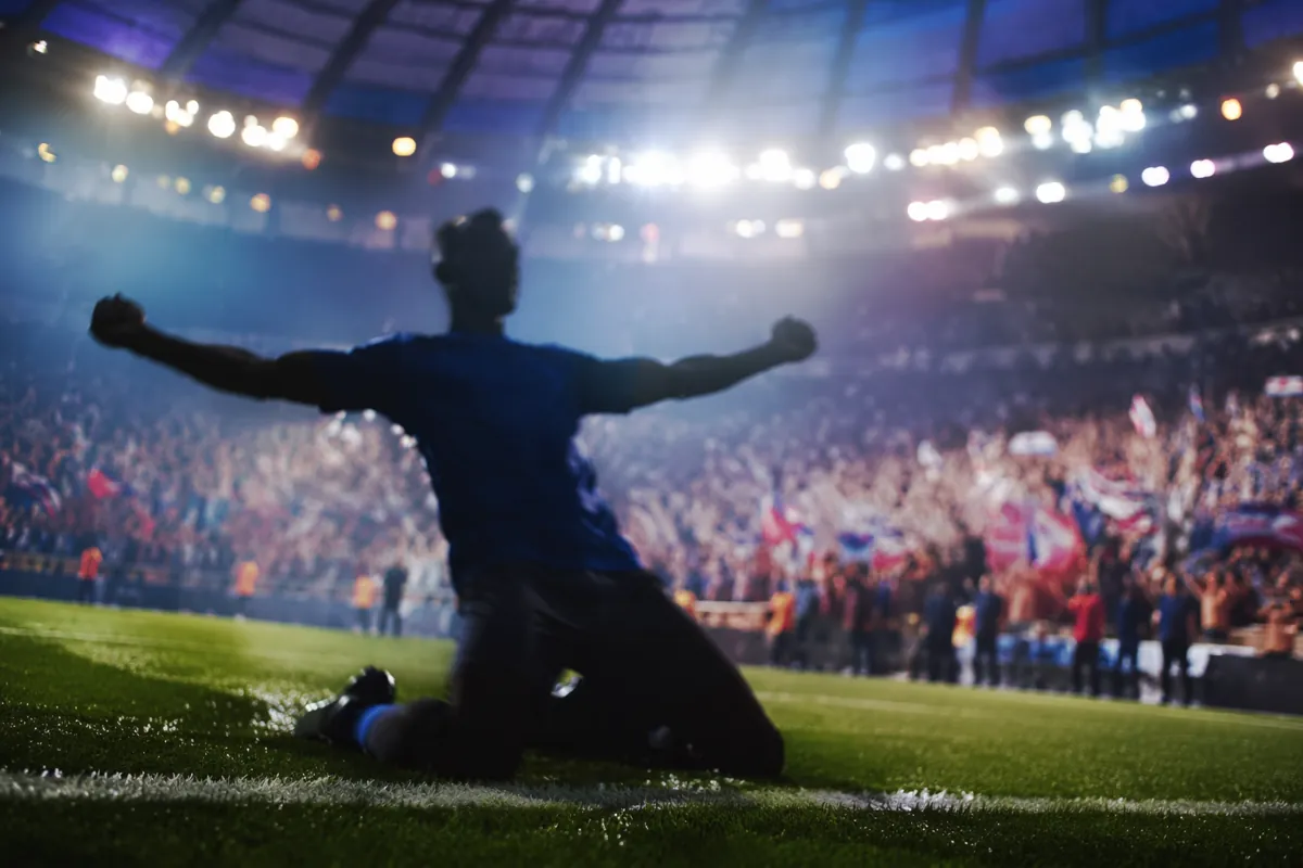 Professional sports news header image, blurred silhouette of a football player celebrating