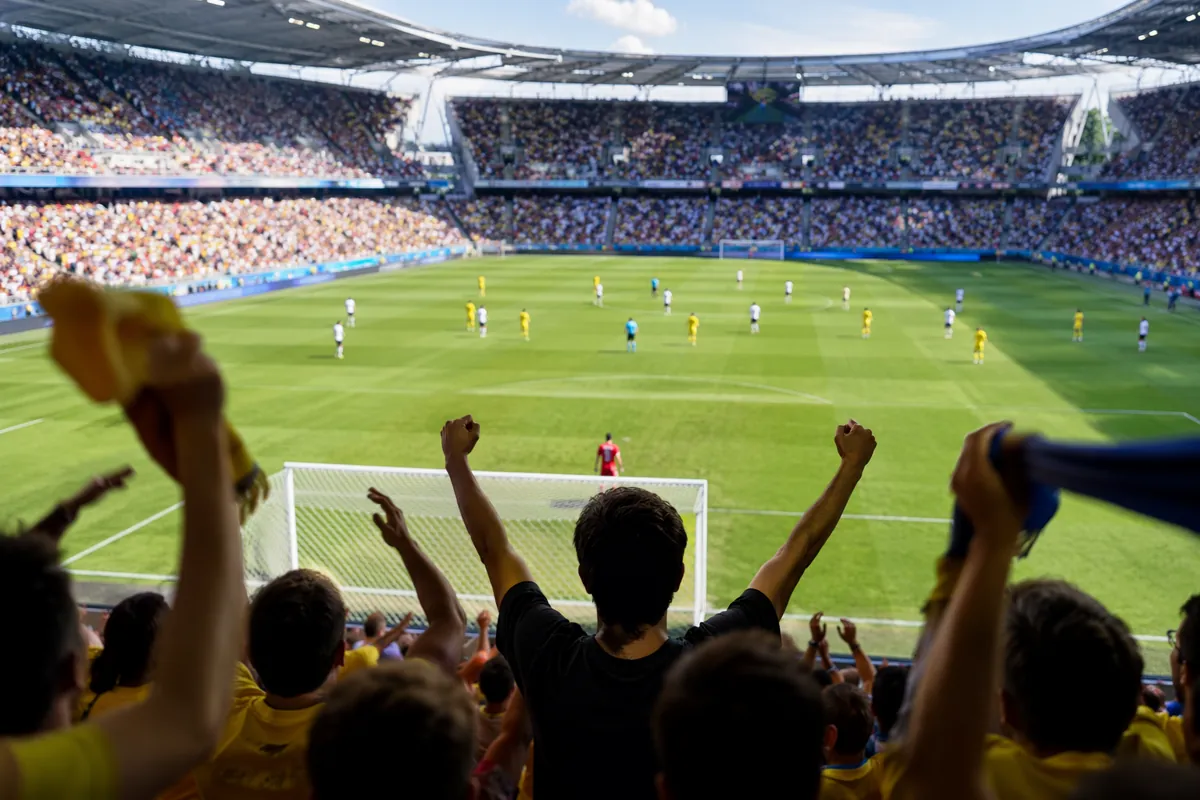 Professional sports news header image, wide shot of a modern soccer stadium during a dayti
