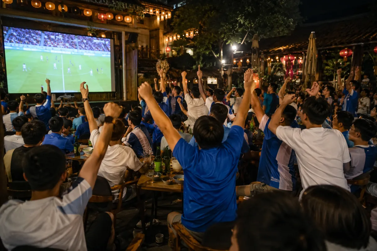 Wide shot of a vibrant World Cup viewing party in Chengdu, China, with fans wearing generi