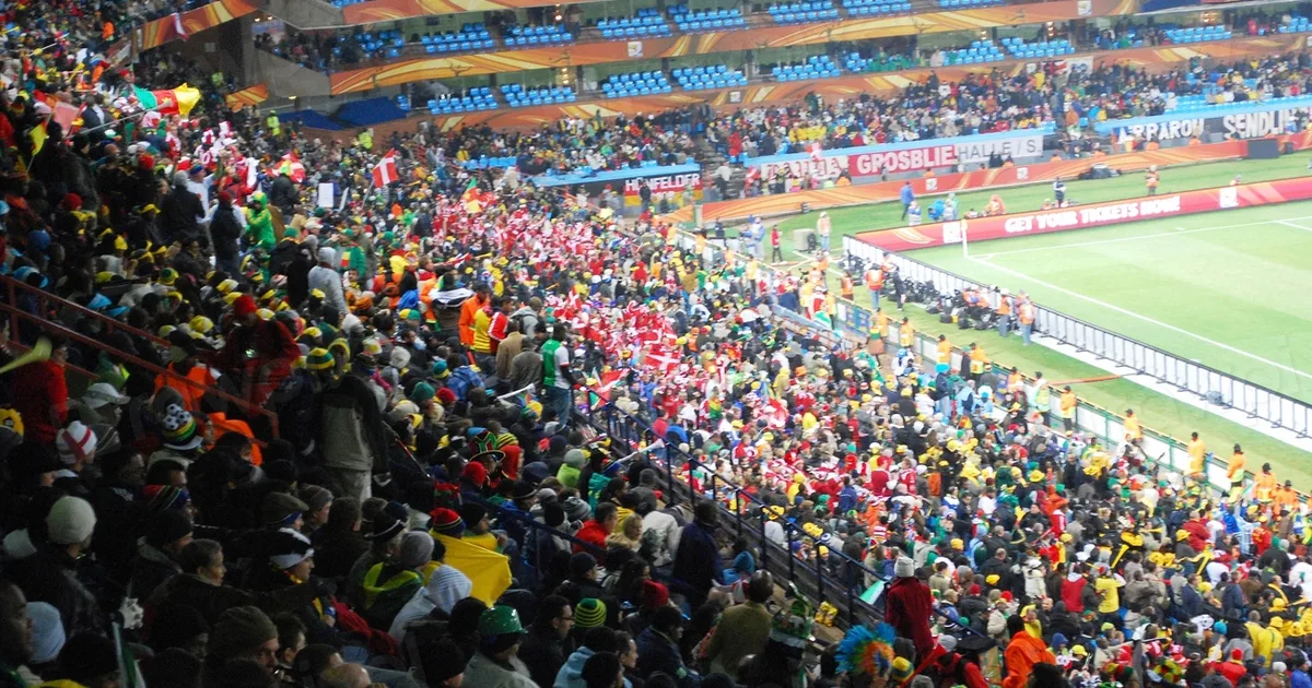 A wide shot of a modern empty FIFA World Cup official conference stage, with football them