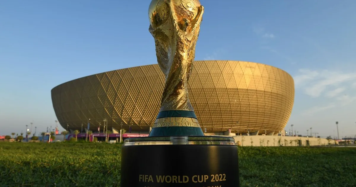 Editorial news feature photo of a golden generic World Cup trophy placed on a dark confere