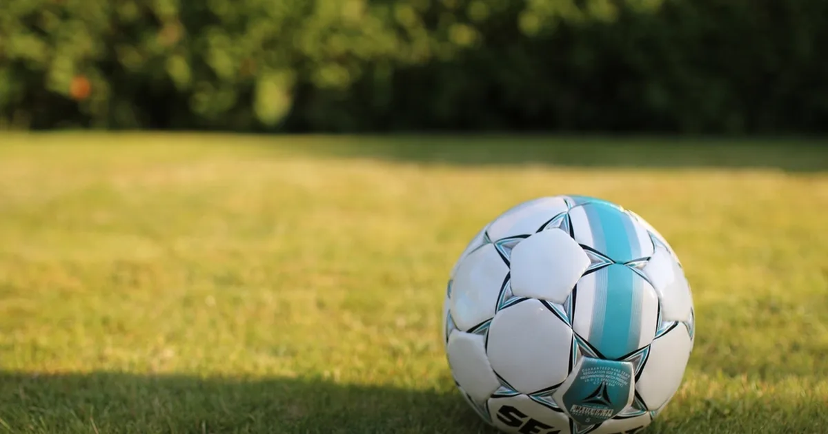 Wide shot of a professional La Liga soccer stadium, green grass pitch under bright sunligh