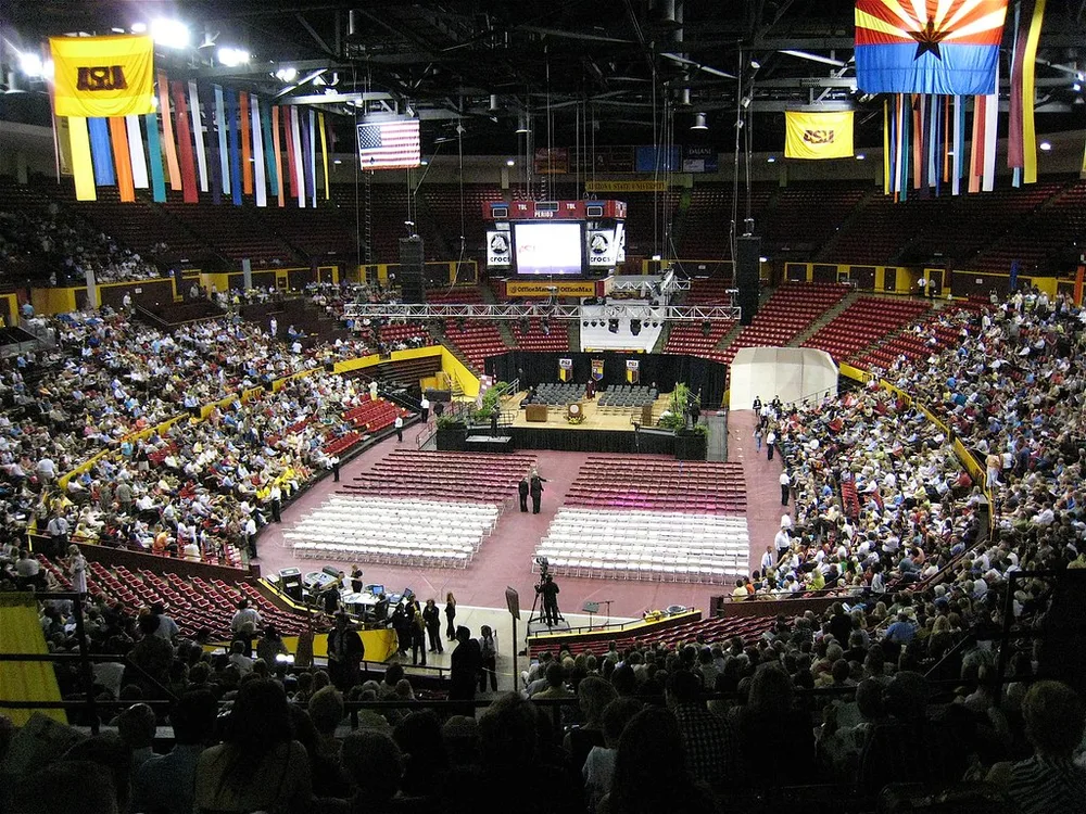 Wide shot of a generic modern football stadium exterior during golden hour, blur