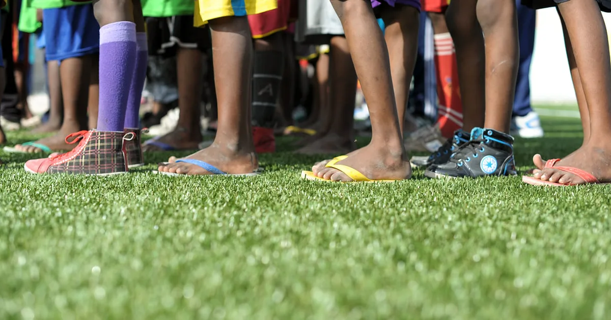 Professional football 11v11 training match on well-maintained green grass pitch, coach sta