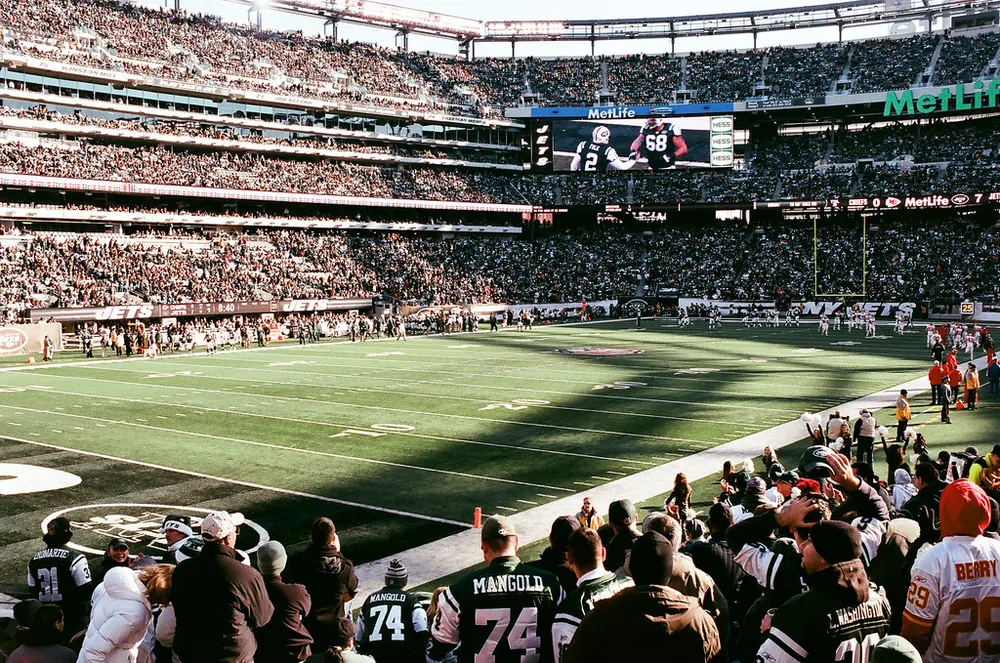 Close-up shot of a football player's feet dribbling a white football on natural