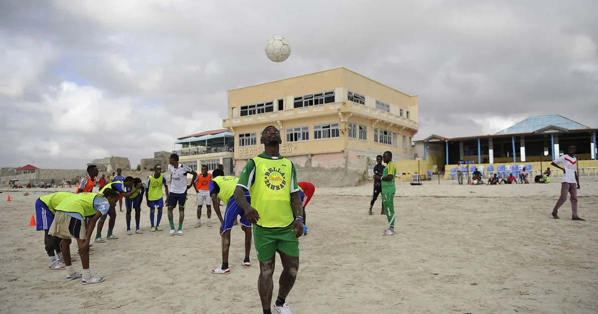 Professional football pre-season training scene, blurred players in red jerseys running on