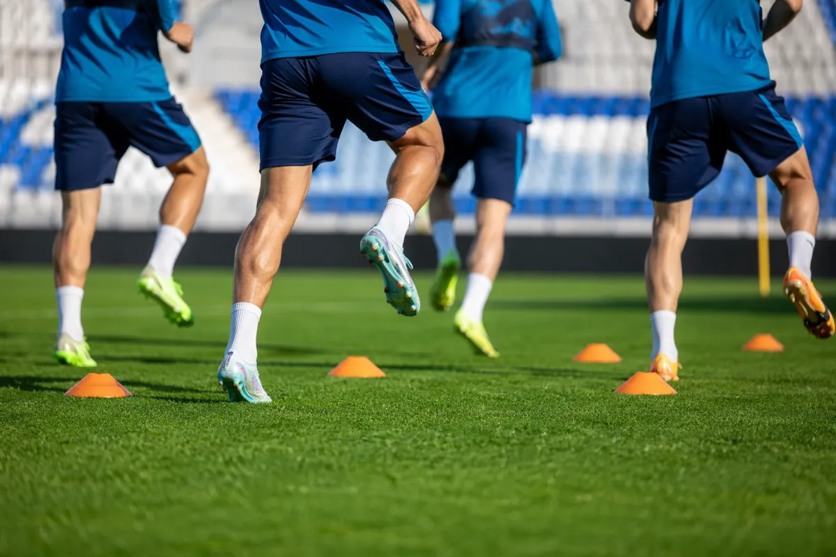 Professional football training session on a well-maintained green pitch, bright sunny weat