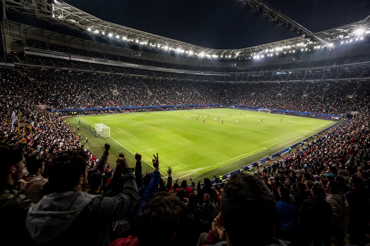 Wide shot of a modern football stadium during a professional match, bright floodlights, bl