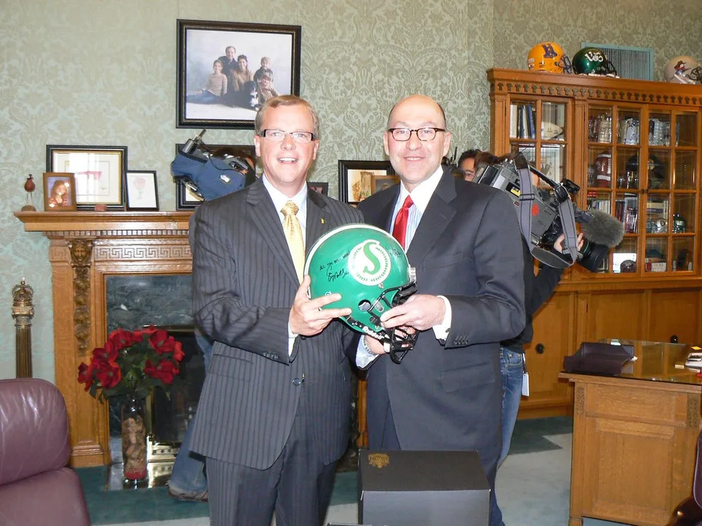 Close up of a traditional leather football on a neatly trimmed green pitch, soft