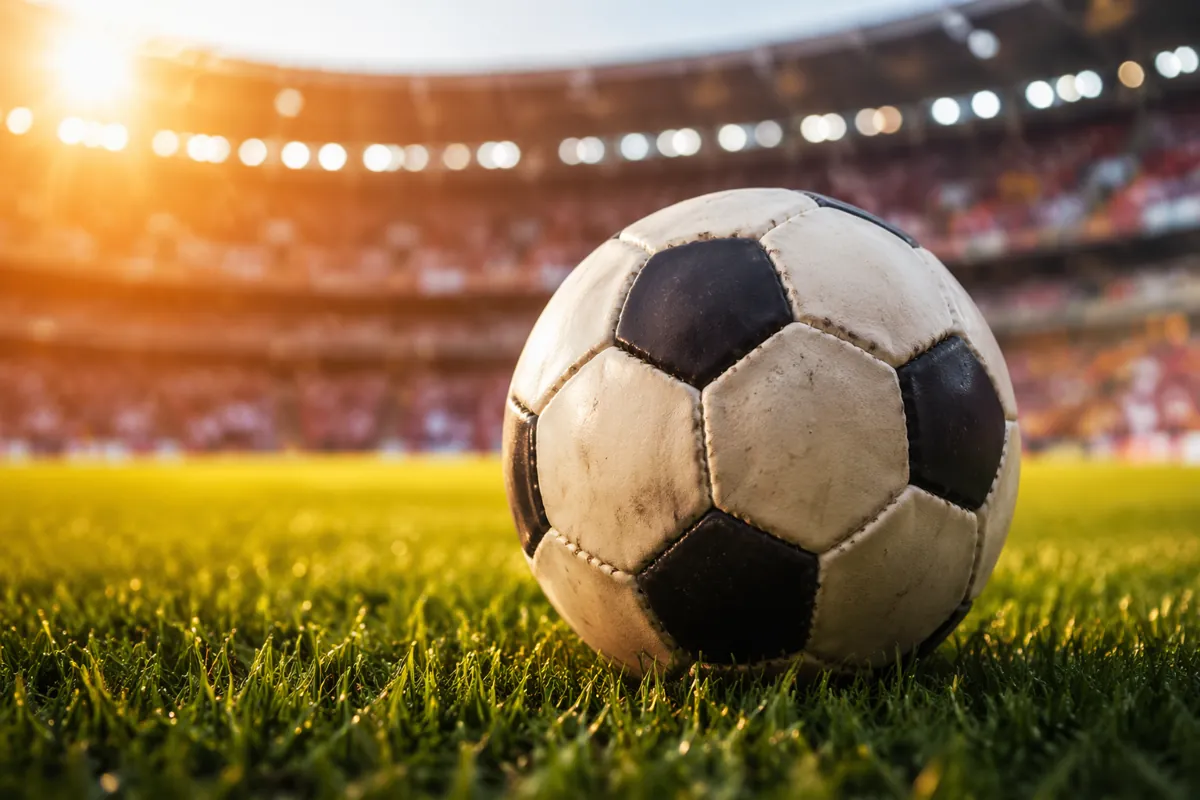 Close-up shot of a traditional football on a well-maintained green World Cup pitch, with b