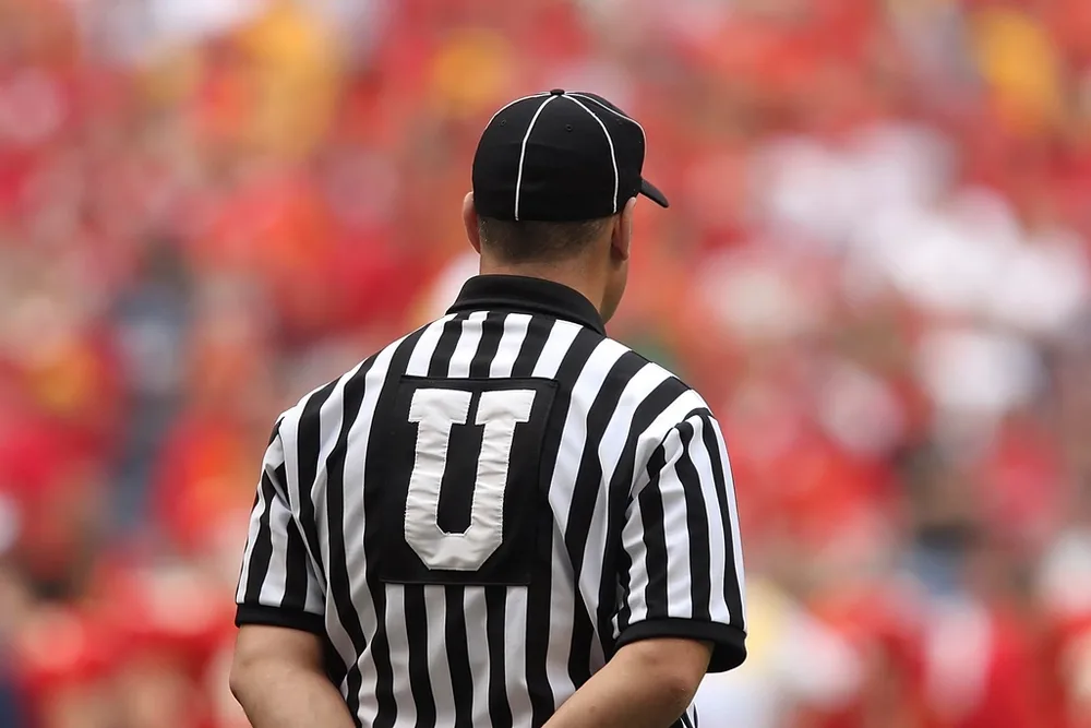 Close up shot of football referee showing a yellow card during a match, blurred