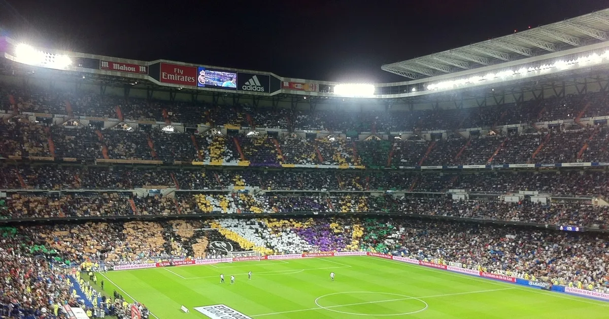 Professional football match scene, bright stadium floodlights, leather football resting on