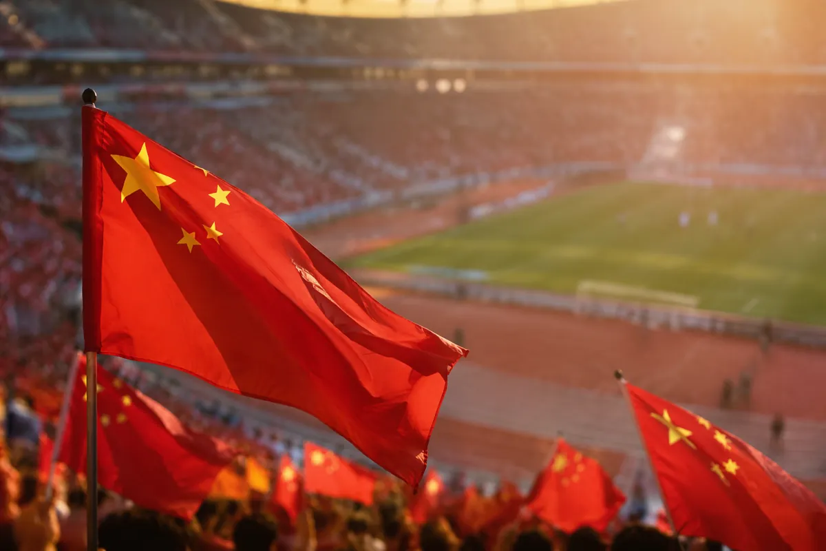 Editorial news feature header, blurred wide shot of a football stadium with Chinese nation