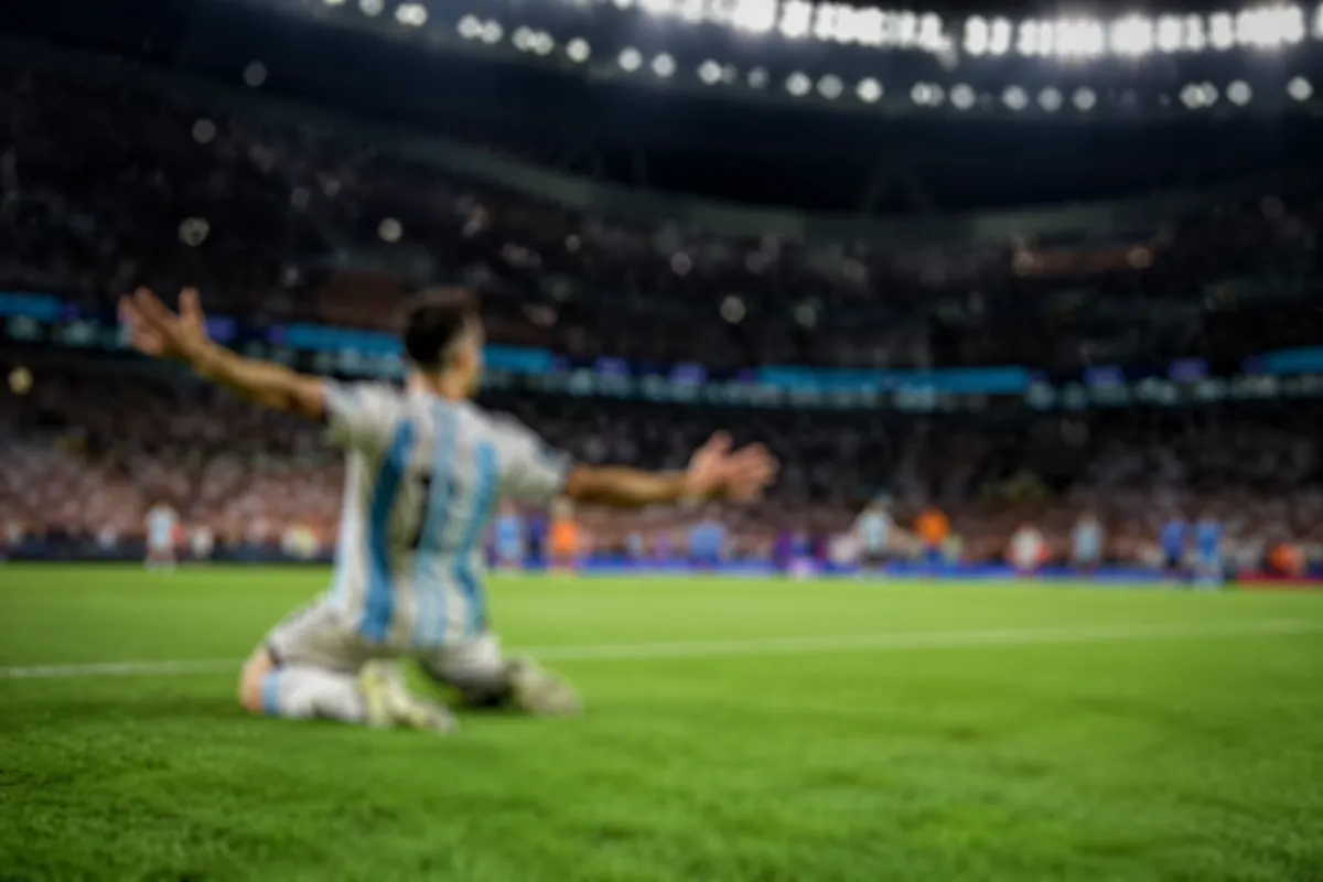 Professional sports news header image, blurred view of a football player celebrating a goa